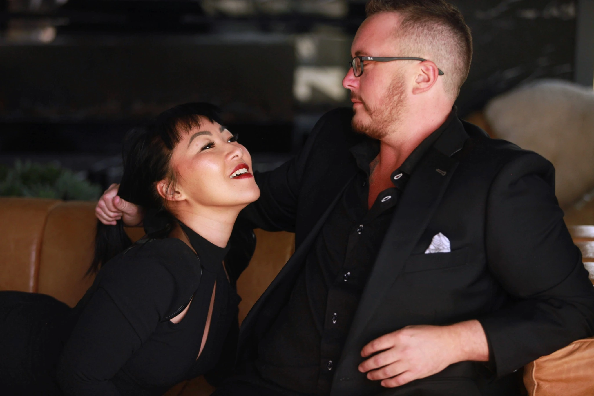 Editorial portrait of Ayce and another person sharing a moment on a couch